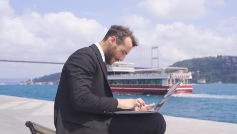 businessman working in his laptop in the bosphorus.