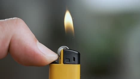 hand lights the lighter. blazing lighter in hand on super slow motion.