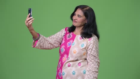 mature happy beautiful indian woman video calling with phone
