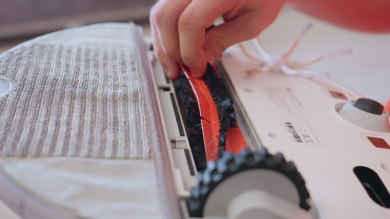 Close up of person hand removing vacuum cleaner component, focusing on careful repair and maintenance process, showing attention to detail during disassembly of household cleaning device