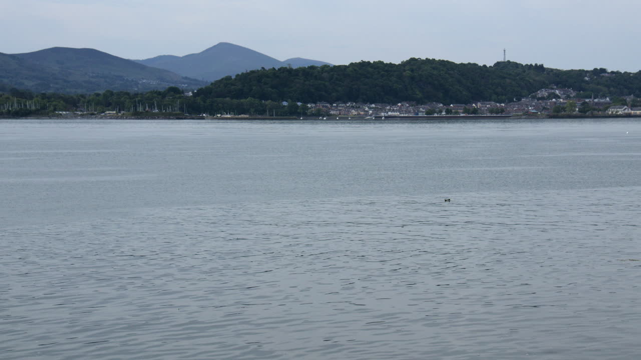 Wide shot looking across the Menai Strait towards Bangor at Gallows point,