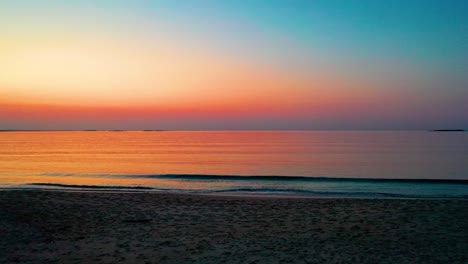 Colorido-Atardecer-En-La-Playa-En-Saco,-Maine,-Con-Colores-Brillantes-Que-Se-Reflejan-En-Las-Tranquilas-Olas-Del-Océano-A-Lo-Largo-De-La-Costa-Atlántica-De-Nueva-Inglaterra