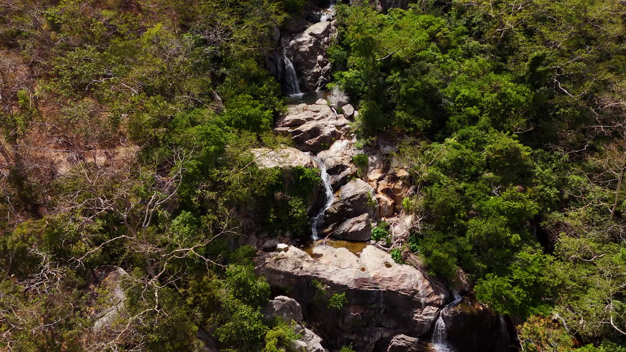 ascenso aéreo inverso revelando una hermosa cascada de la selva en el sureste de asia, vietnam