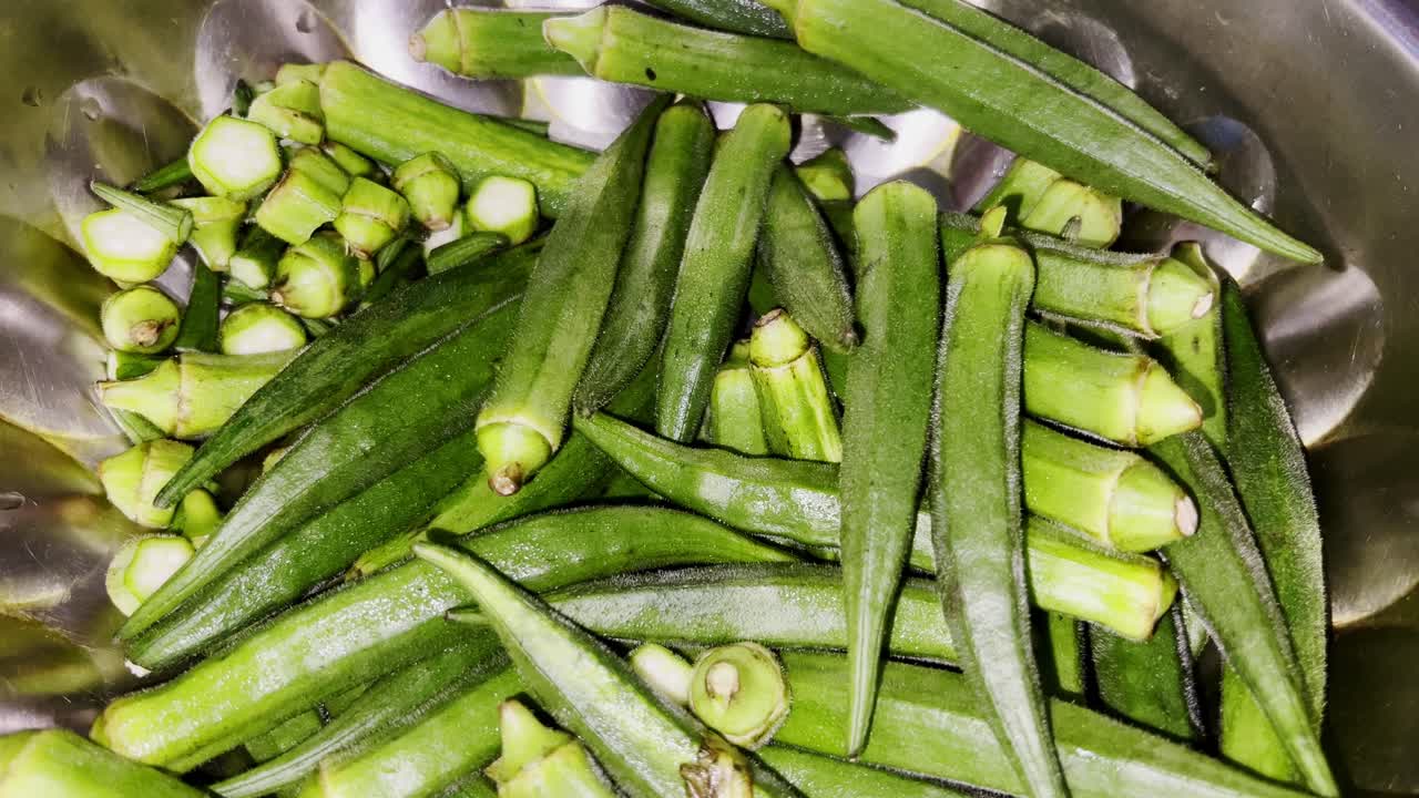 Mumbai, Maharastra, India- July 13th -2024-Compact tilt up high speed shot of Indian woman cutting ladyfinger in early fresh morning.