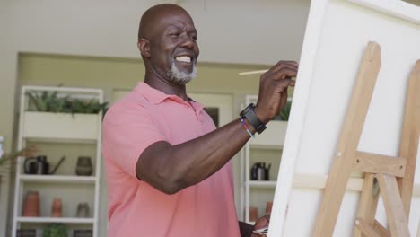 Happy-senior-african-american-man-painting-in-slow-motion