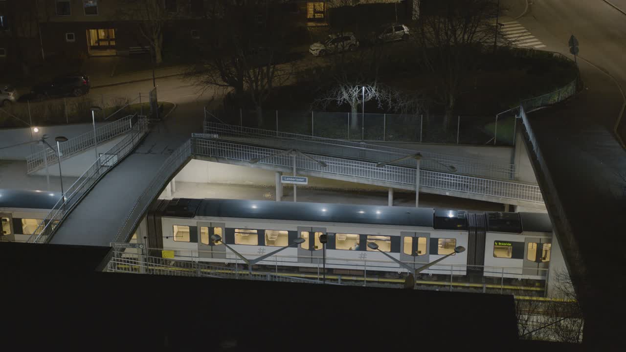 Oslo metro arriving at Lambertseter station in the evening with passangers disembarking as train drives away