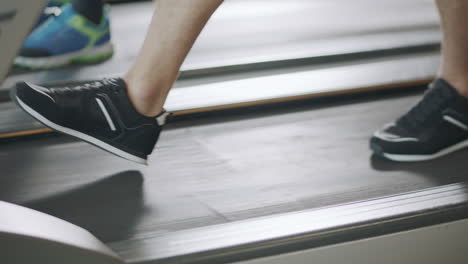 closeup feet walking on treadmill in fitness gym slowly.