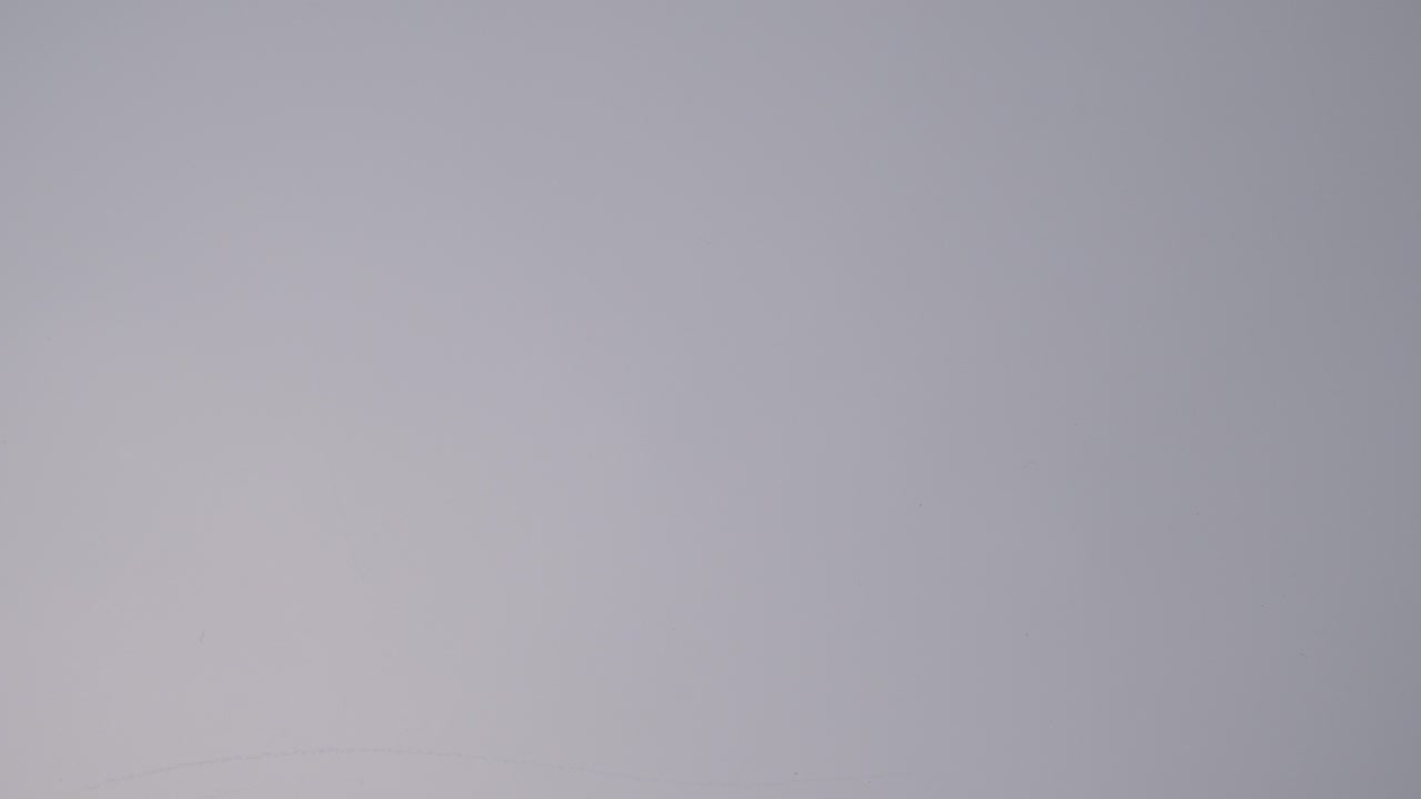 vida muerta de béisbol con una persona recogiendo el bate y la pelota contra un fondo gris