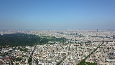 Aerial-panoramic-footage-of-large-city.-Town-development-in-urban-boroughs.-Vast-woodland-Bois-de-Boulogne-and-dominant-Eiffel-Tower-in-distance.-Paris,-France