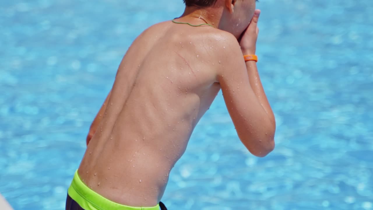 Boy jumping in pool. Happy boy jumping into the swimming pool