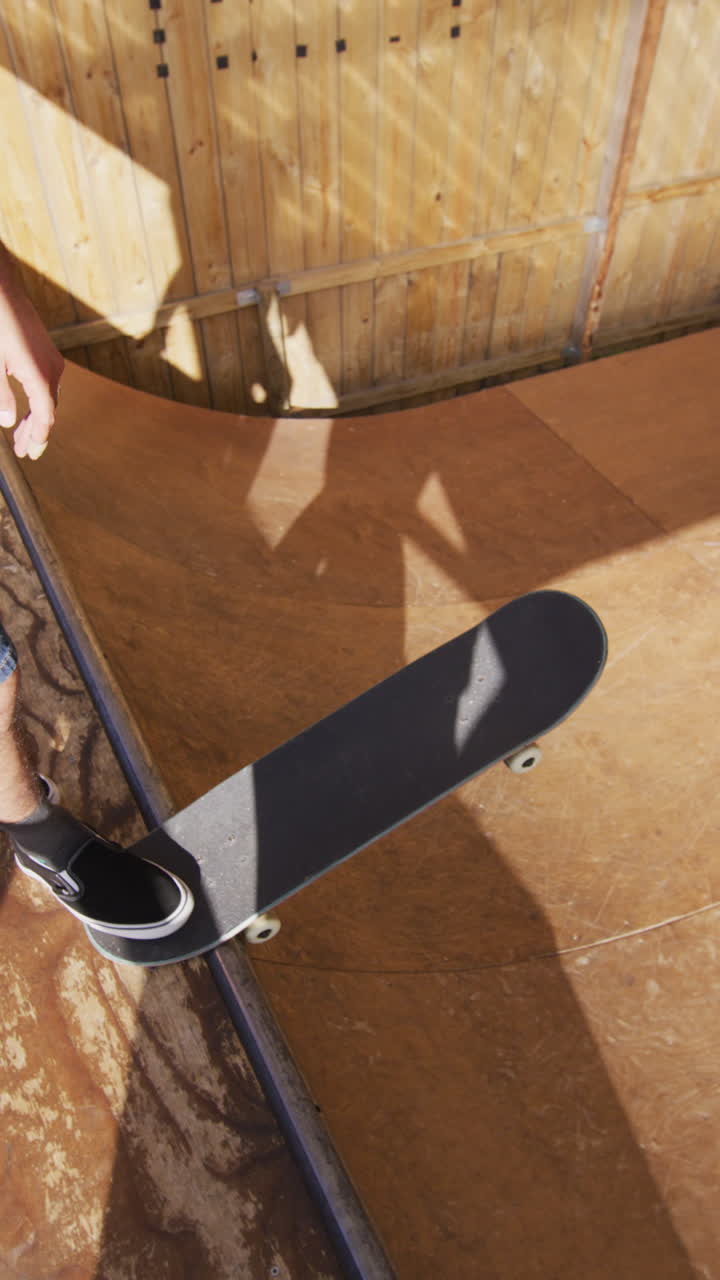 video vertical de un hombre caucásico patinando en un parque de patinaje