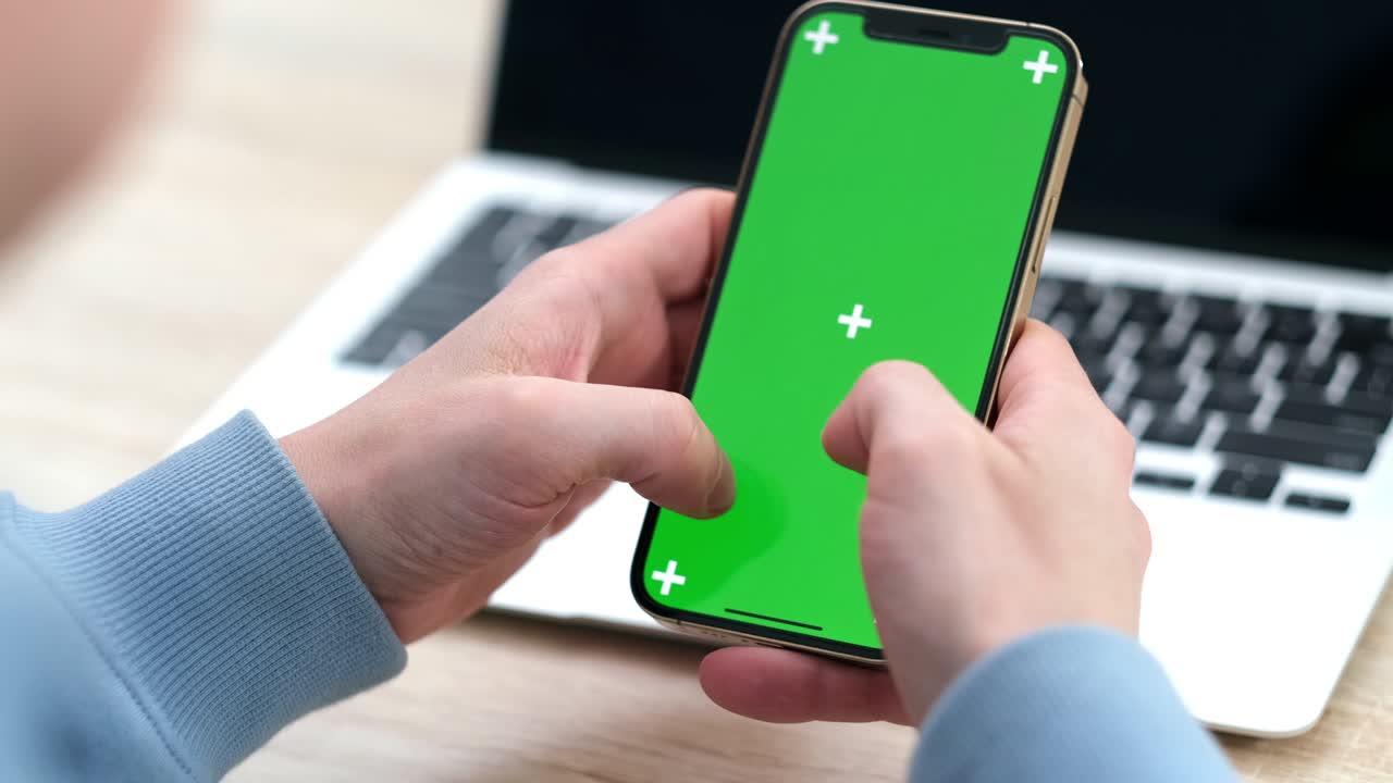 hombre usando un teléfono inteligente iphone 12 viendo pantalla verde en el teléfono presionando la tecla chroma en línea escribiendo texto leyendo redes sociales de cerca manos 24.04.21 san petrosburgo rusia