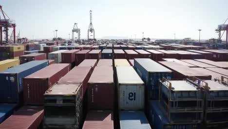 aerial view of shipping containers stacked in a port, highlighting the complexity of global trade and logistics operations