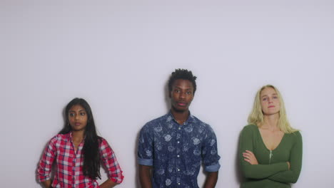 3 young people leaning against wall space