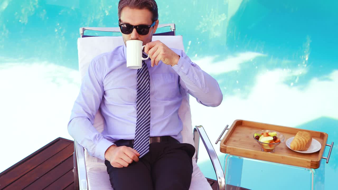 Hombre apuesto con gafas de sol bebiendo café