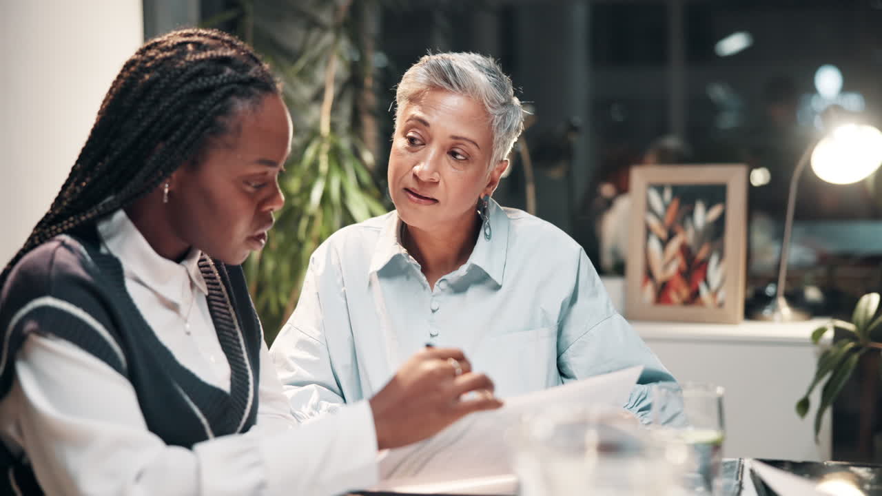 Two Businesswomen Discussing Documents at a Table