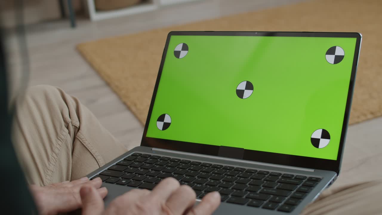 persona irreconocible que utiliza una computadora portátil con pantalla verde