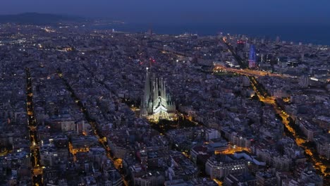 aerial view of barcelona eixample residential district and famous basilica sagrada familia during blue hour. catalonia, spain