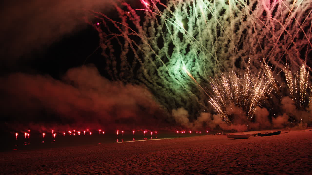 Colorful fireworks explode on the ocean beach on New Year's Eve
