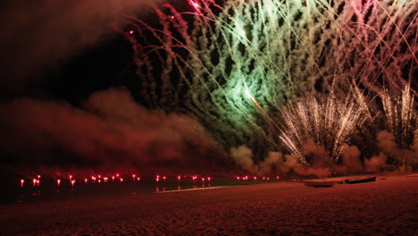 Colorful fireworks explode on the ocean beach on New Year&#039;s Eve