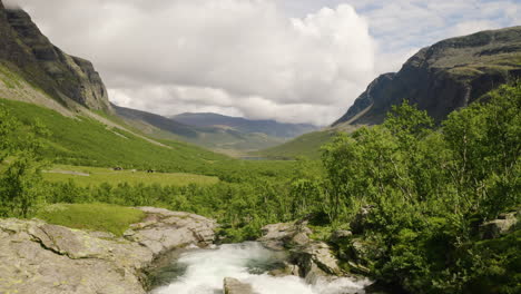 paisaje impresionante en el valle de hydalen en hemsedal con cascada de agua dulce a través del exuberante follaje - una joya escondida en noruega - disparo ascendente de drones, gran angular