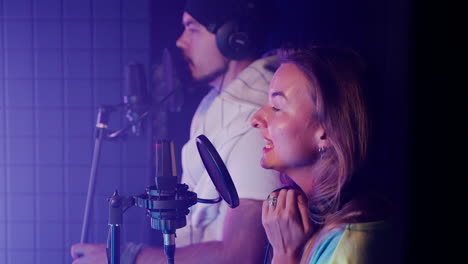 two people recording vocals in a music studio