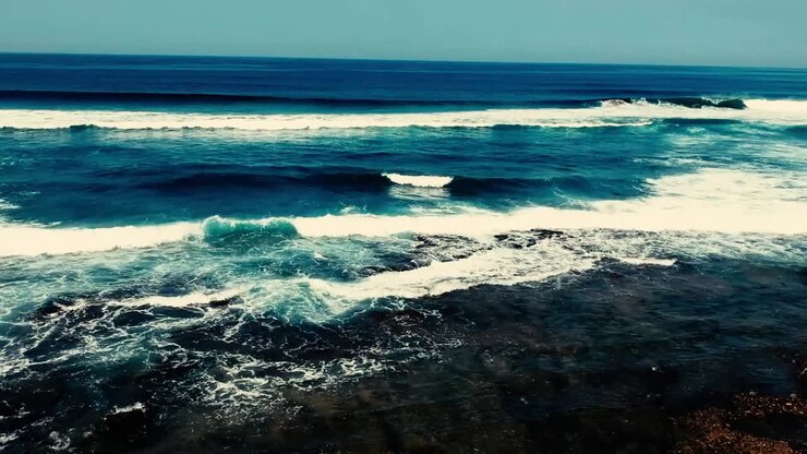 Images aériennes filmées par un drone surplombant la plage et la mer avec des vagues déferlantes et un océan d'un bleu profond sur le Bluff en Afrique, dans l'hémisphère sud
