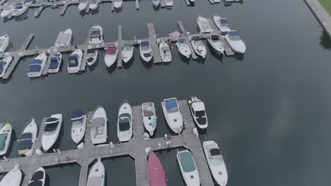 amazing-view-from-the-air-of-jetty,-pier-in-the-city,-many-boats-in-a-beautiful-sunset-overlooking-the-buildings