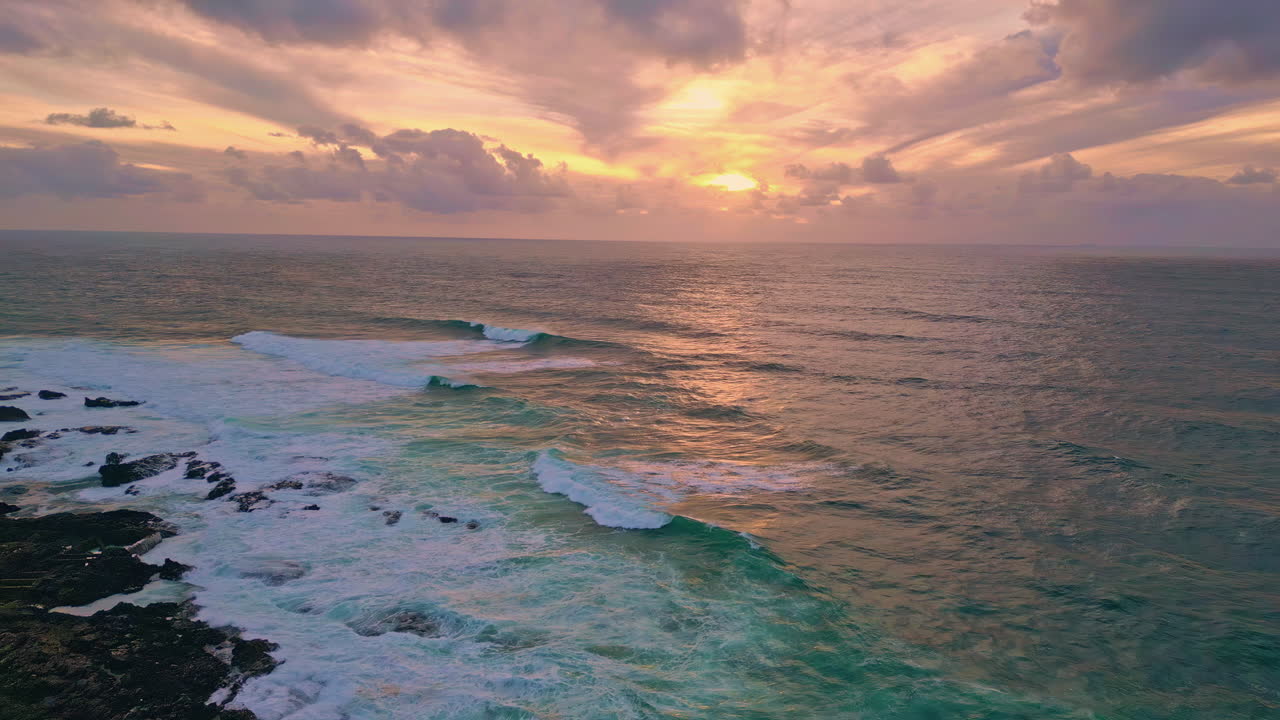 Marine sunrise ocean waves crashing of coastal cliffs aerial view. Golden light