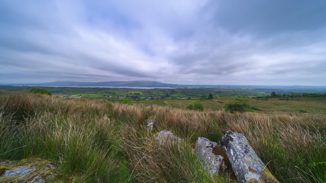Panorama motion time lapse of rural landscape with rocky grassland hillside and lake in the distance on a spring cloudy day in Arigna mountains in county Leitrim in Ireland