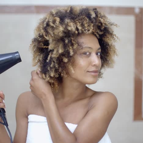 mujer secándose el pelo con secador de pelo