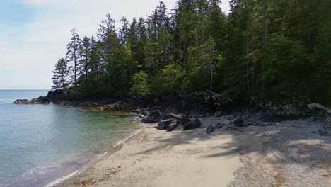 moresby island along a coastal beach with forest trees, aerial dolly shot, bc, canada