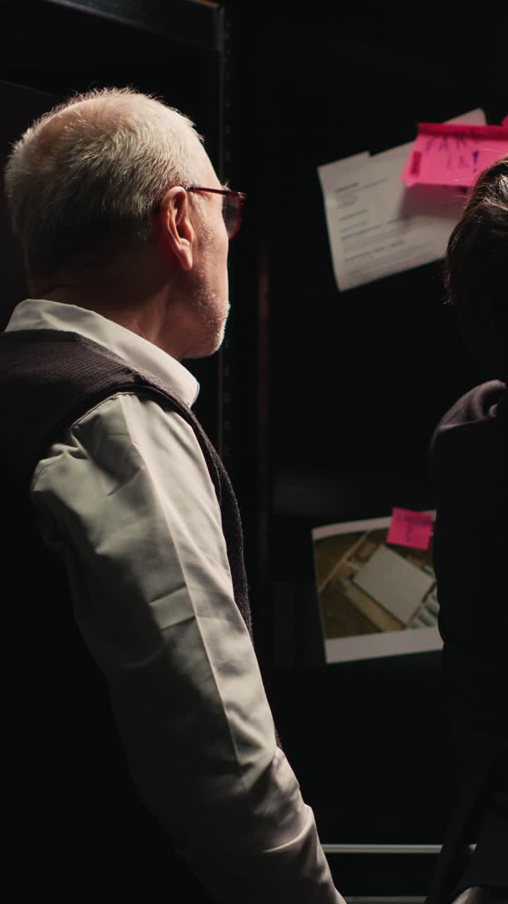 Vertical video Police agents examine evidence board