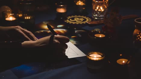 close up of woman drawing astrology lagna or birth chart on candlelit table 3