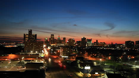 traffic flows along the streets of a city and buildings are lit up at night