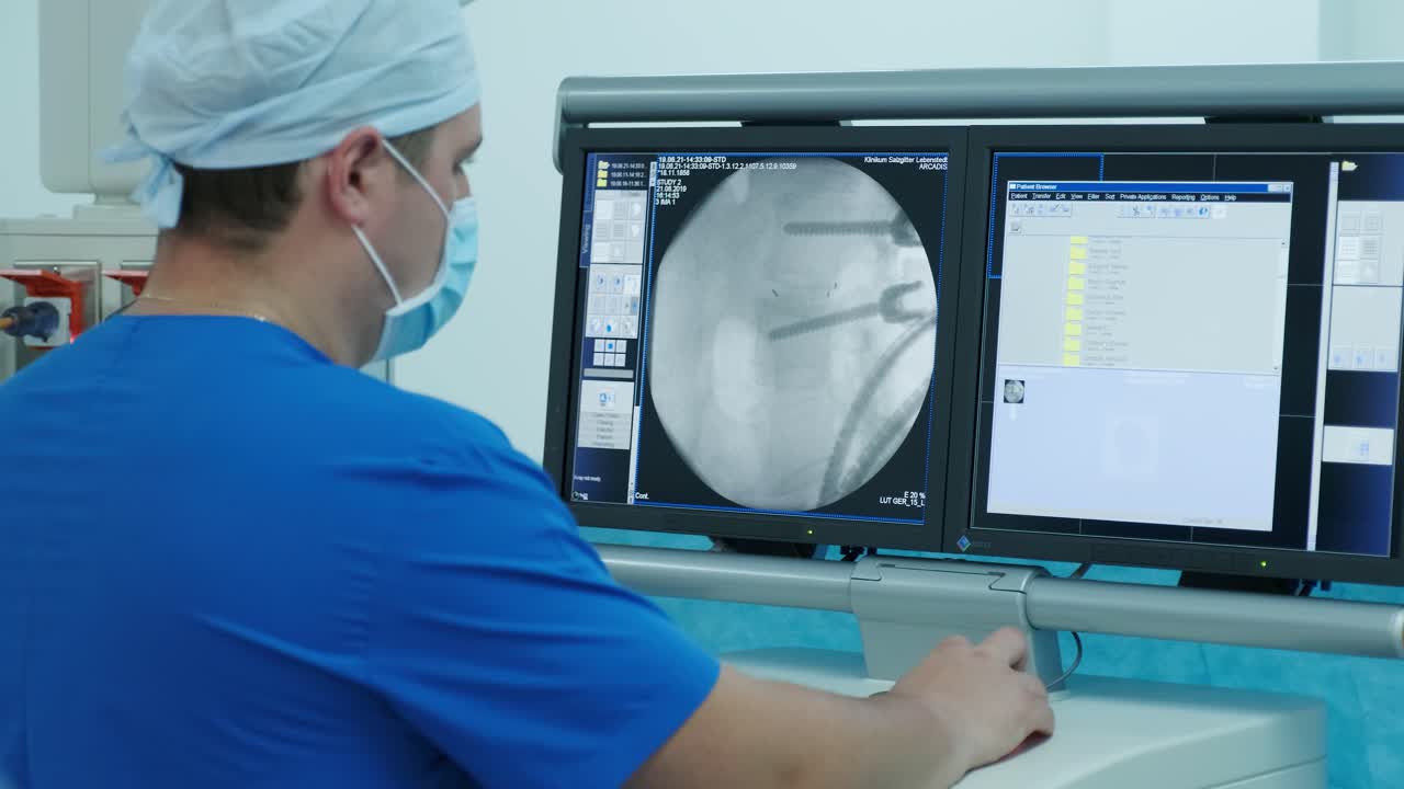 의사는 모니터에서 스레이를 검사합니다.