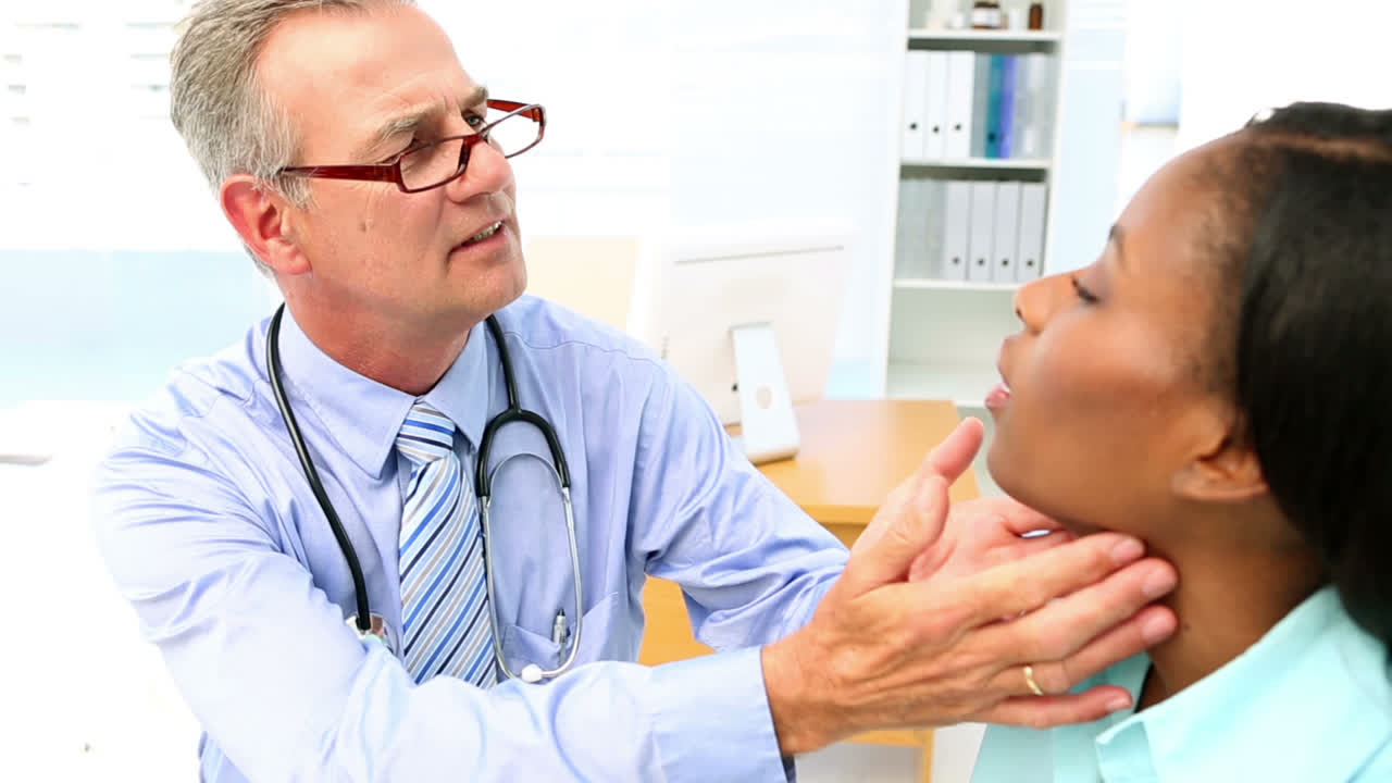 의사가 환자의 목구을 검사하고 있습니다.