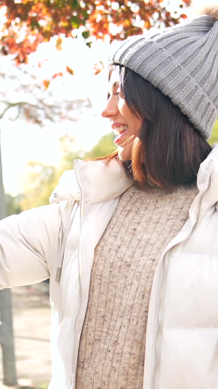 Woman in autumn setting wearing beanie and jacket