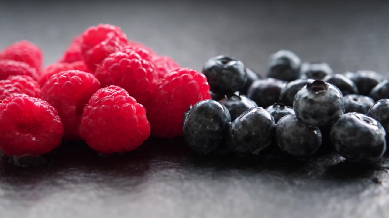 Detailed closeup shots capture the vibrant hues, delicate textures, and juicy appeal of raspberries and blueberries, highlighting their freshness and natural beauty in stunning clarity.