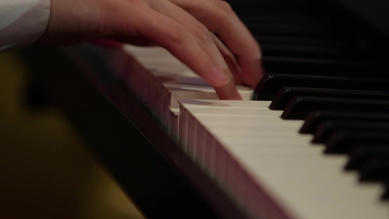 Young man hands playing piano at live event