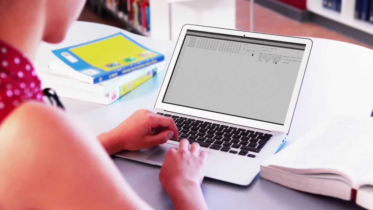 Caucasian woman sitting at desk coding data on laptop