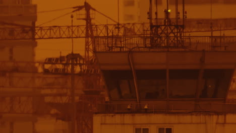 close up of air traffic control tower in airport at sunset with orange sky