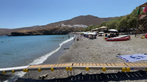 greece, astypalea, livadi beach, a disabled ramp by the beach to serve disabled people to reach the sea easily. a sunny day by the beach, at the end of the footage a person armpit crutch by the ramp.