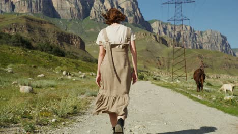 woman walking in a mountainous rural landscape