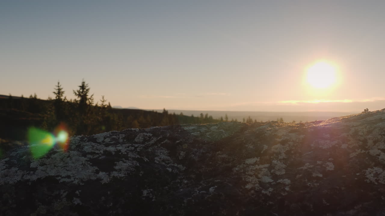 los pies del viajero en la cima del pico a través de ellos brilla el sol naciente y el hermoso paisaje