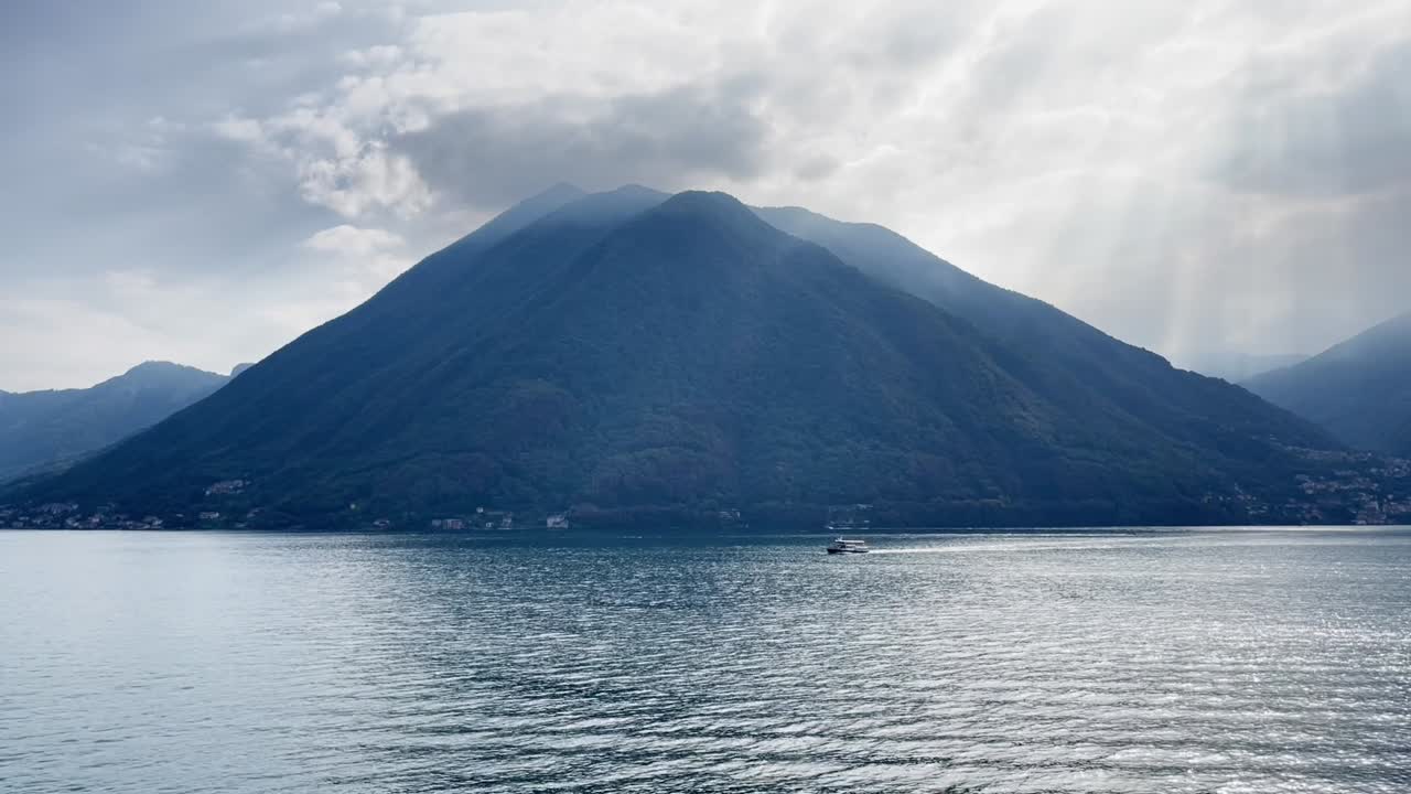 toma amplia del lago de como con un pequeño bote en el medio