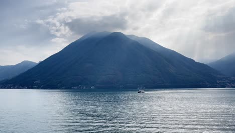 Toma-Amplia-Del-Lago-De-Como-Con-Un-Pequeño-Bote-En-El-Medio