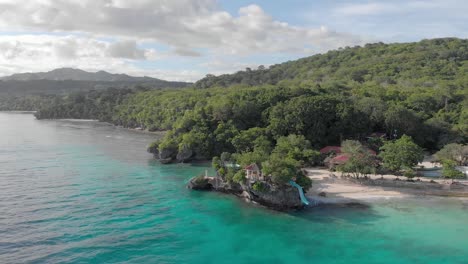 Toma-Aérea-Cinematográfica-De-Drones-Del-Icónico-Resort-En-La-Isla-De-Filipinas,-Con-Agua-Azul-Cristalina,-Arena-Blanca-Y-Acantilados-Saltando-En-Un-Caluroso-Día-Soleado-De-Verano