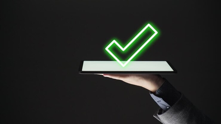 Business man showing approved check mark on a tablet