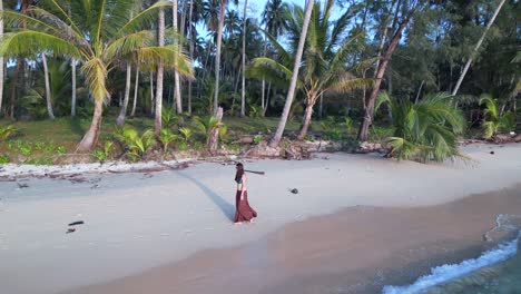 Woman-walking-with-long-skirt-on-the-beach-coastline-wave